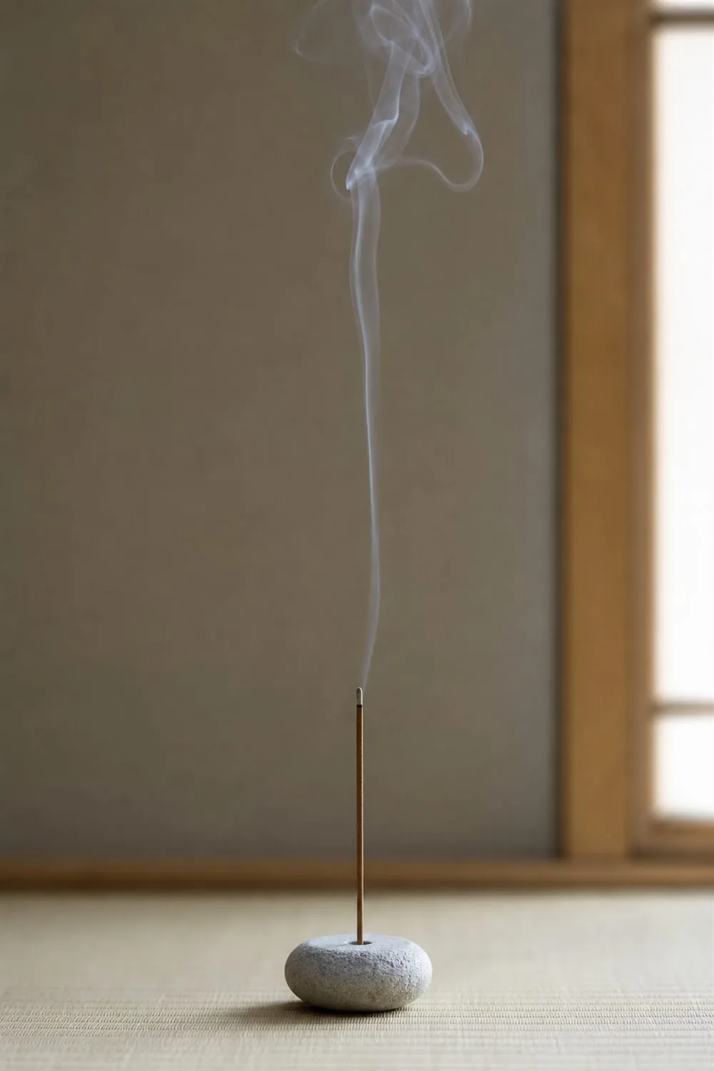 石の香立てに立てたお香から細い煙がまっすぐ立ちのぼる