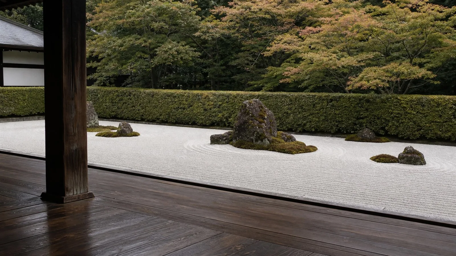 京都の寺院の縁側から望む枯山水の庭 — 白砂に描かれた砂紋と苔むした石